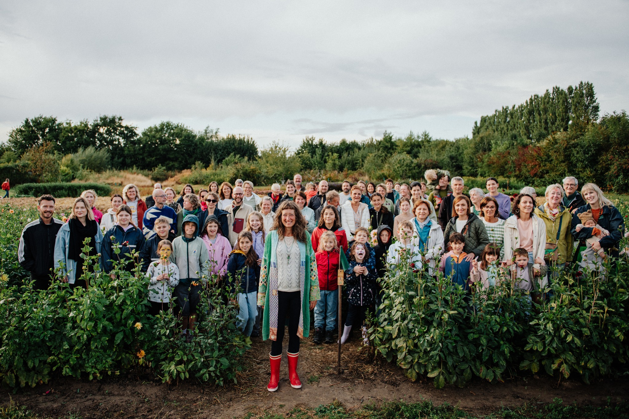Portrait of the farmer tending rows with watering can, natural candid expression, evening light, authentic connection.