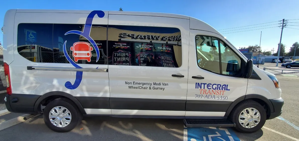 Side view of an Integral Transit van showing the logo and the phone number 707-ADA-5350