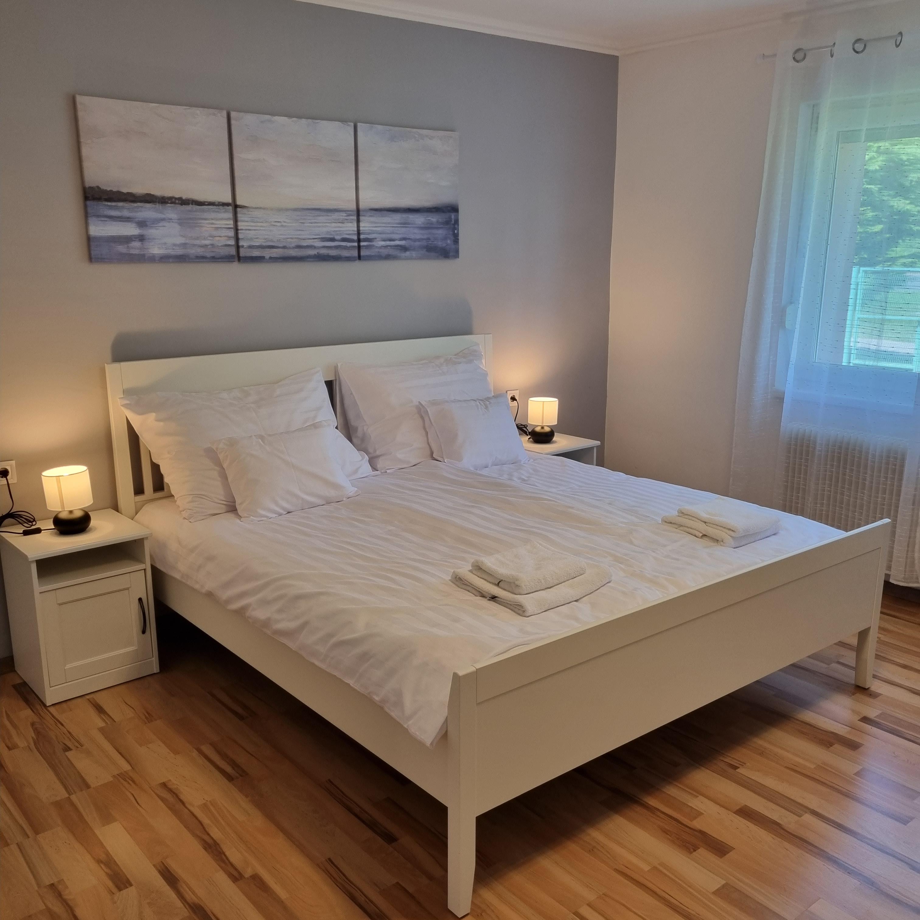 white bed linen near white wooden nightstand