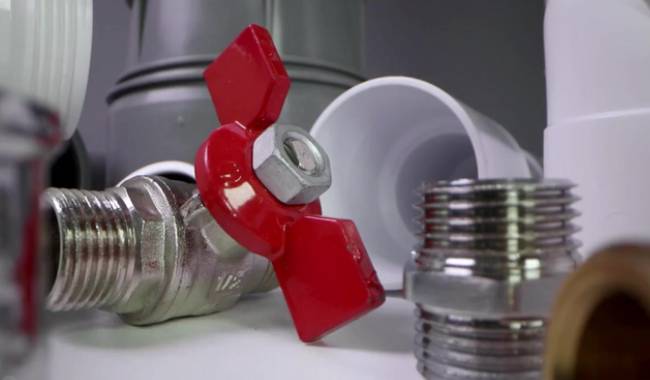 Close up of metal plumbing valves and PVC pipe fittings