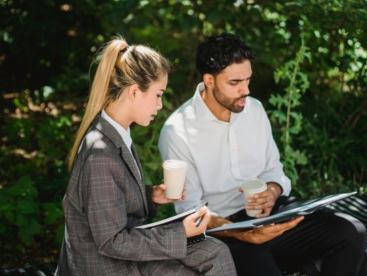 Man and woman studying on a park bench