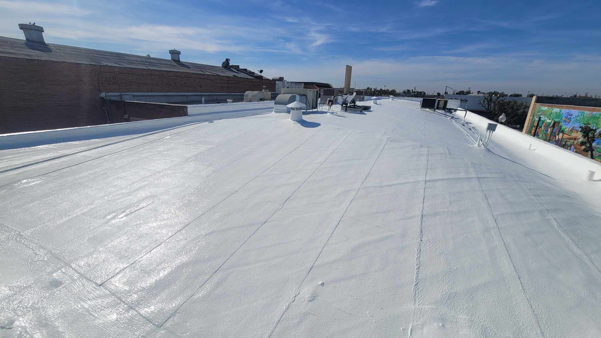Roof coating and restoration work on a building in Bakersfield, CA