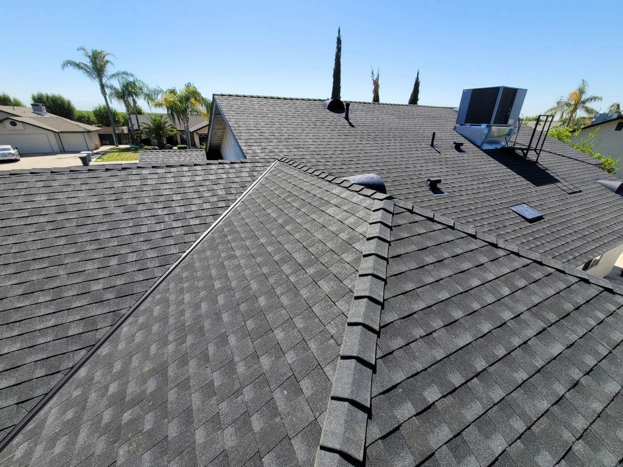 New charcoal architectural shingle roof with ridge caps on a Kern County home