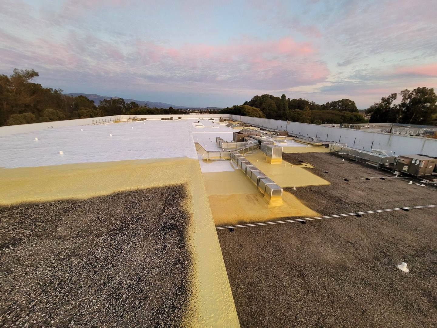 Kern County commercial roof going from old gravel to yellow spray foam to finished white coating