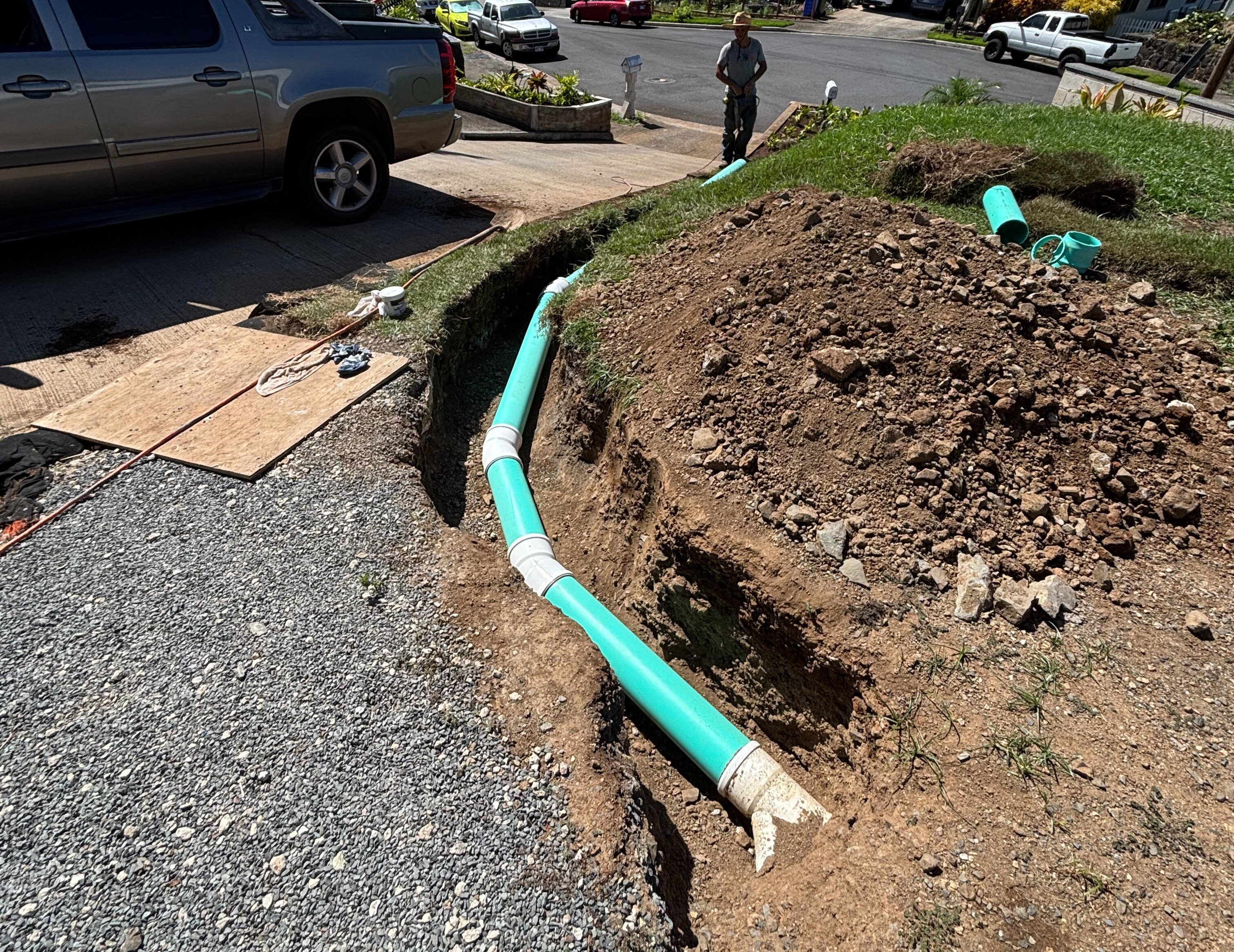 French drain installation with perforated piping and gravel trenching for yard drainage in Kapa‘a, Kauai.