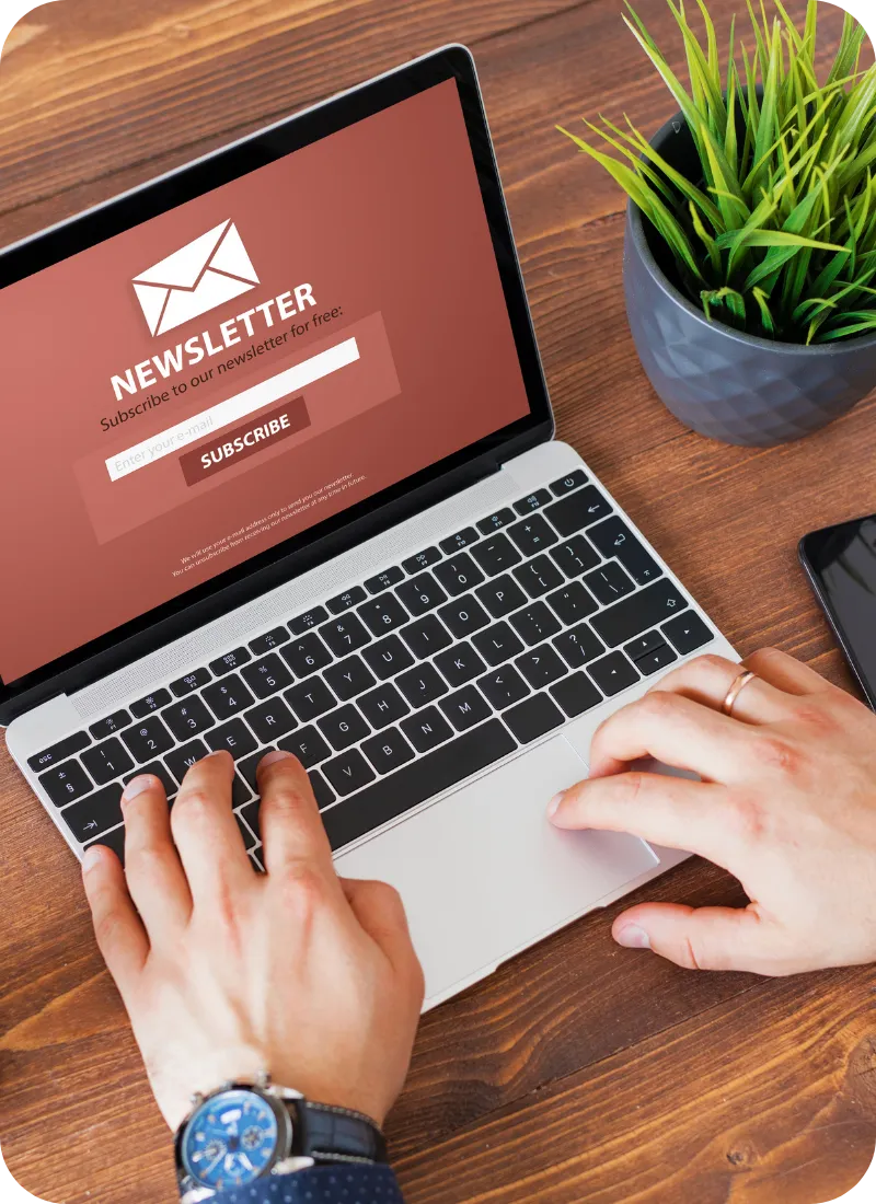 Laptop displaying newsletter subscription page on desk for home inspection email marketing signup