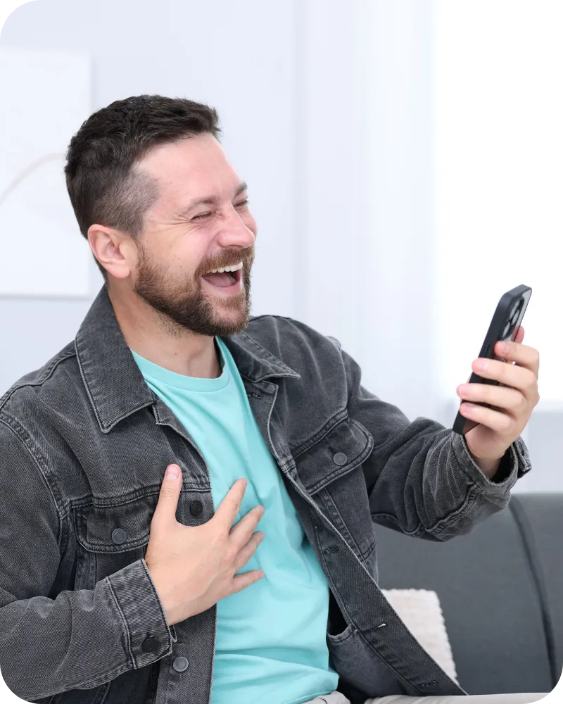 Home inspector smiling while reading a message on his smartphone after receiving positive client feedback