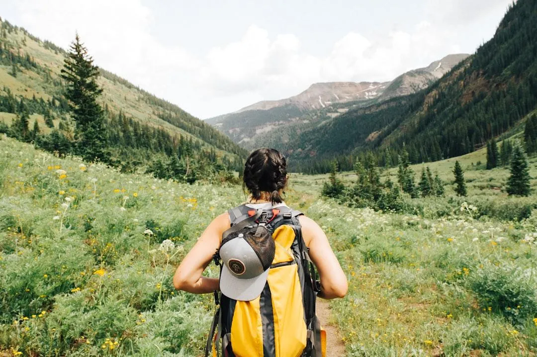 Woman walking through prairie at base of mountain