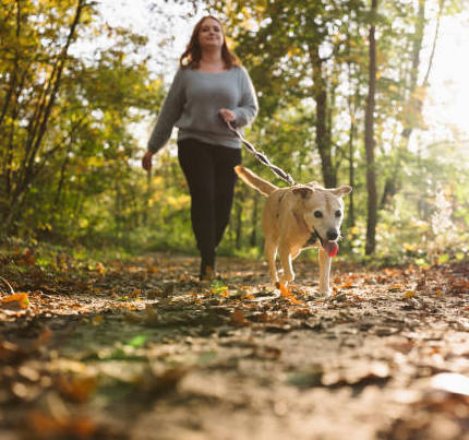 Woman walking on outdoor trail with dog