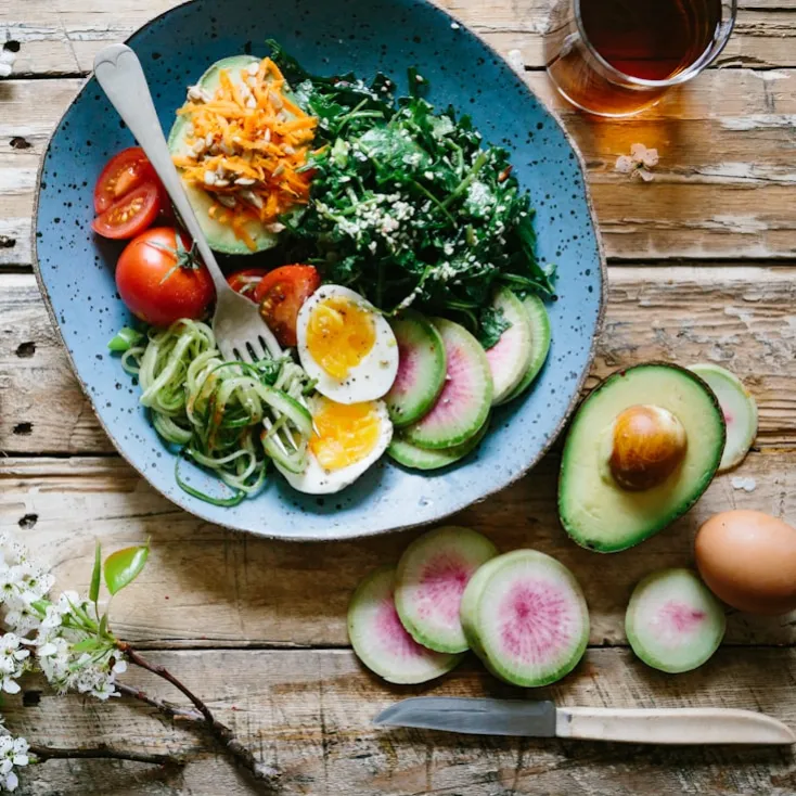Table with plate of healthy vegetables and eggs