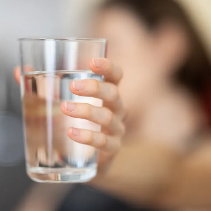 Woman's hand holding glass of water