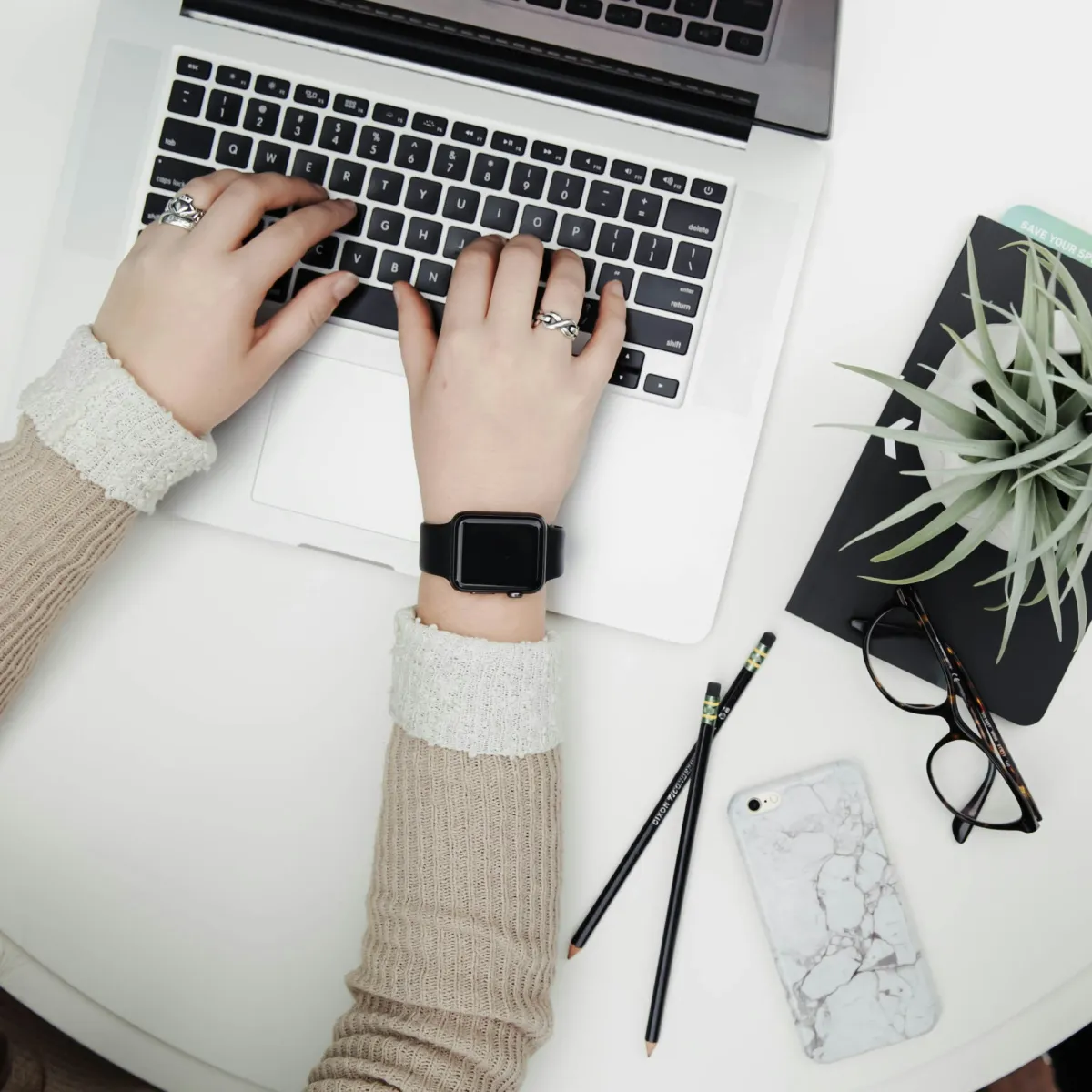 Bird's eye view of woman sitting at white table working on laptop