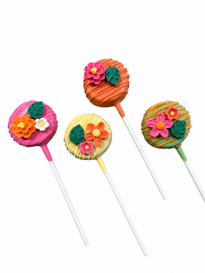 Tropical luau cake pops in pink, orange, yellow, and green with fondant flowers and monstera leaves