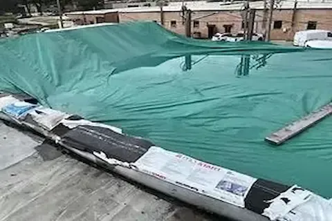 Emergency tarps covering storm-damaged commercial roof in Coon Rapids by Coon Rapids Commercial Roofing