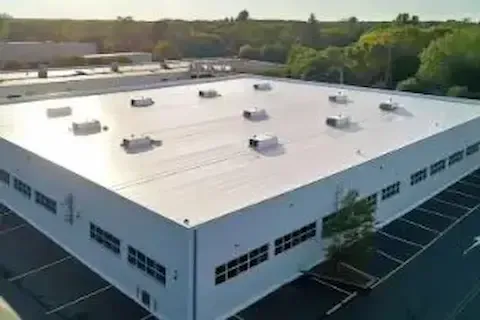 Aerial view of completed white flat roof on Coon Rapids commercial building by Coon Rapids Commercial Roofing