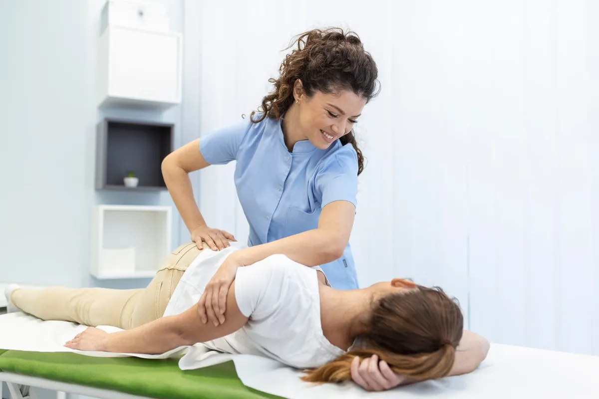 Clinician positioning a patient's back during a spinal care session