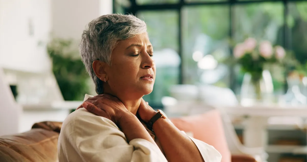 Woman holding her neck and shoulder because of desk-related neck discomfort