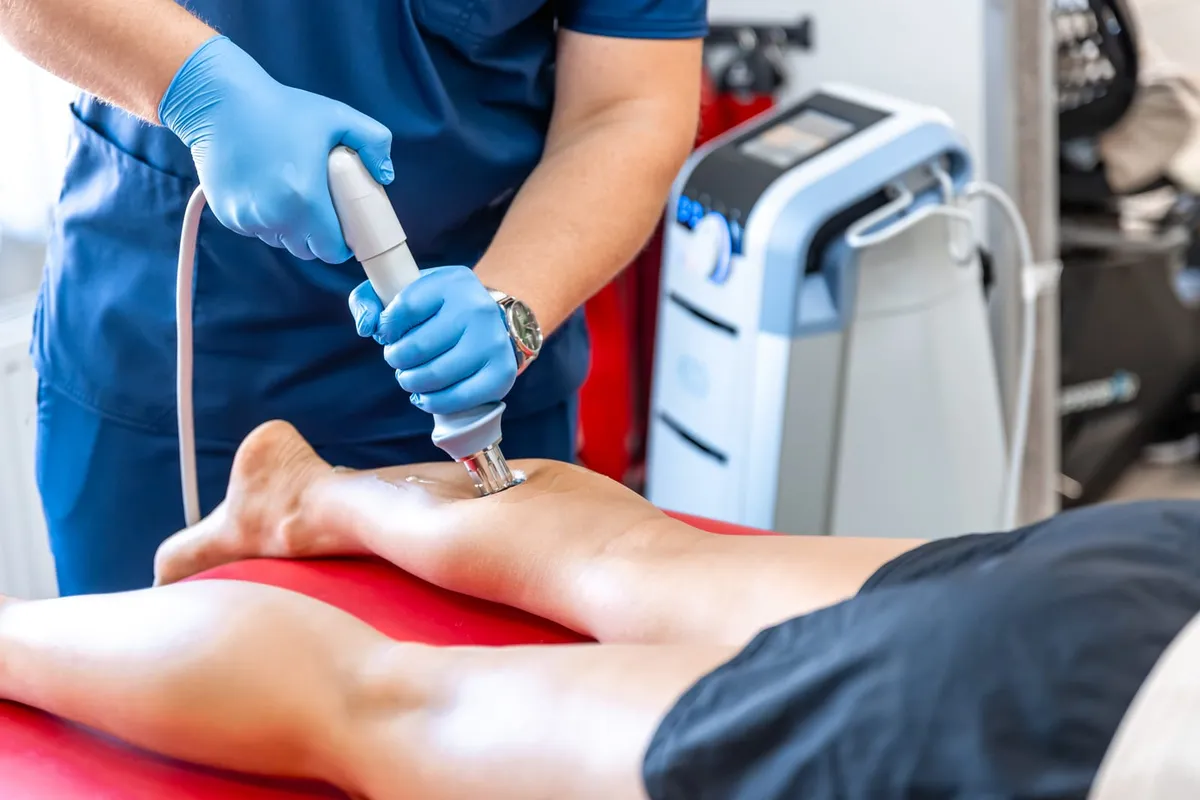 Clinician applying shockwave therapy to a patient's leg