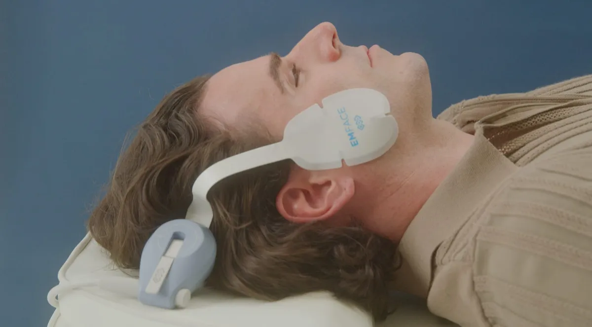 Man relaxing during an Emface facial treatment with applicators on his face