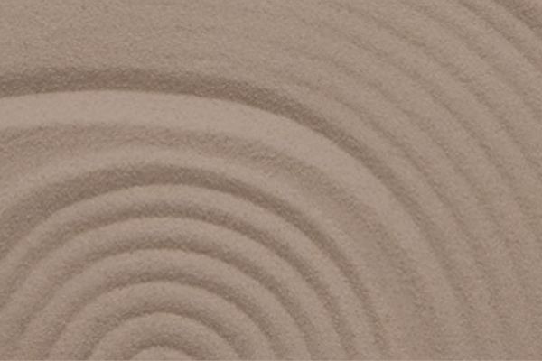 Spiral in the sand representing embodying divine feminine energy through stillness and presence