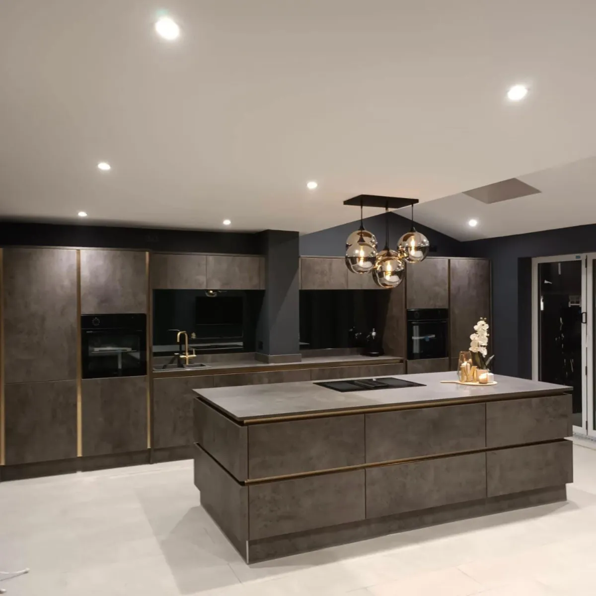 Modern German kitchen in Saltaire and also done in Halifax by Bradford Bespoke Kitchens featuring matte slab cabinetry, brown/gold fixtures and handlesless design