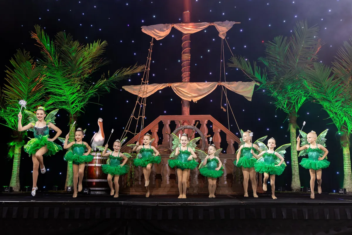 Star Factory Supreme performance team on stage in sparkling green fairytale costumes, dancing with wands during a magical routine, capturing the creativity, confidence, and elite-level performance opportunities offered in Joondalup’s premier dance program.