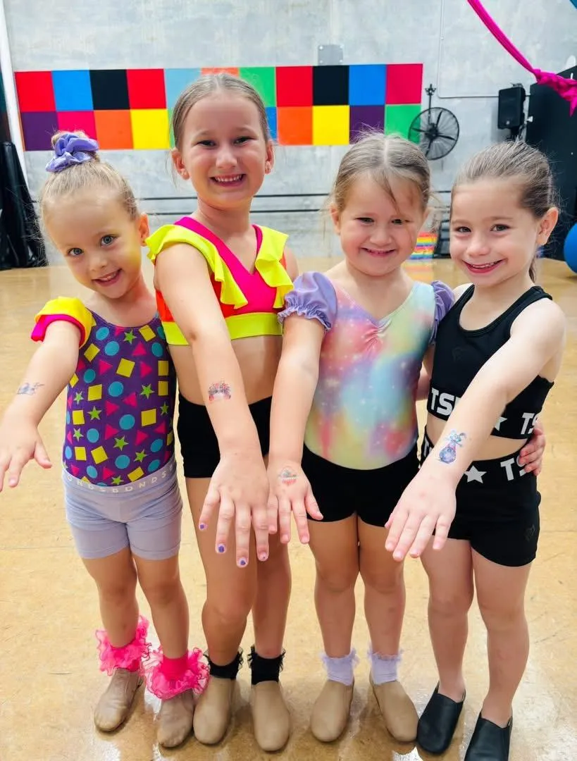 Four joyful girls showing off their temporary tattoos and colourful nail art after class at The Star Factory Joondalup, capturing fun, creativity, and community spirit in kids' dance programs.