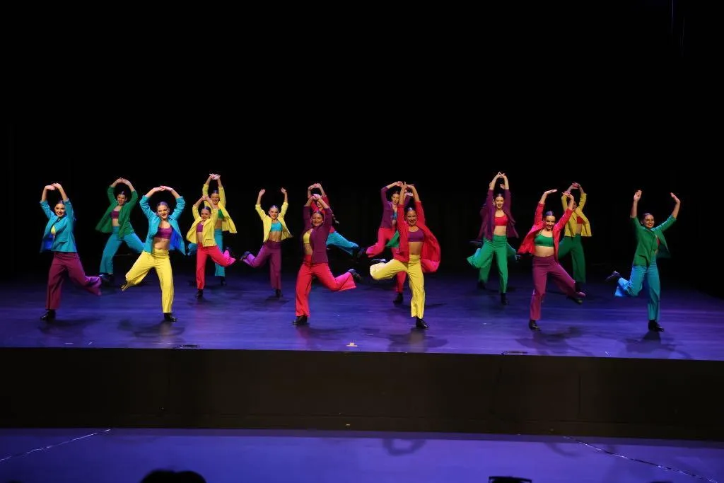 Teen dancers in colorful suits perform a rhythmic tap routine on stage, spotlighting musicality, timing, and performance polish in The Star Factory Joondalup’s tap program.