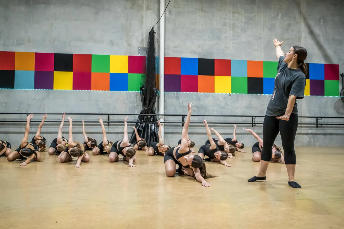Teen girls follow their teacher’s lead in a contemporary dance pose at The Star Factory Joondalup, conveying emotion, technique, and artistic expression in our contemporary classes.