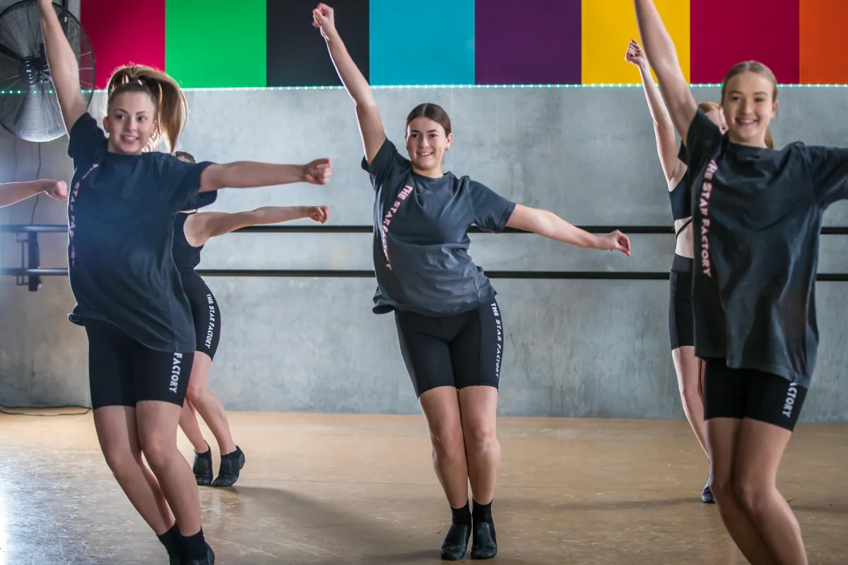 Dancers strike dynamic jazz poses in The Star Factory uniforms inside their studio at Joondalup, showing energy, precision, and performance flair in our jazz dance training.