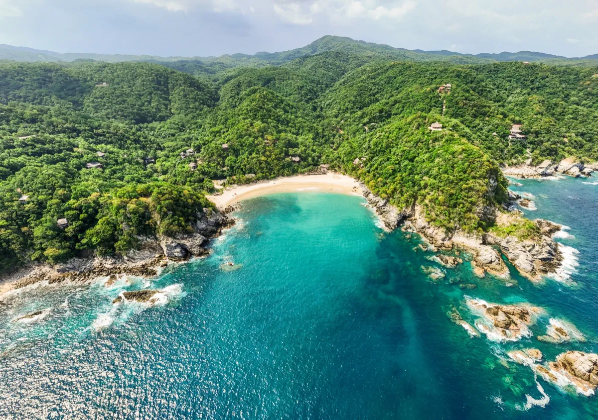 Secluded sandy cove and tranquil emerald ocean waters along Costa Esmeralda