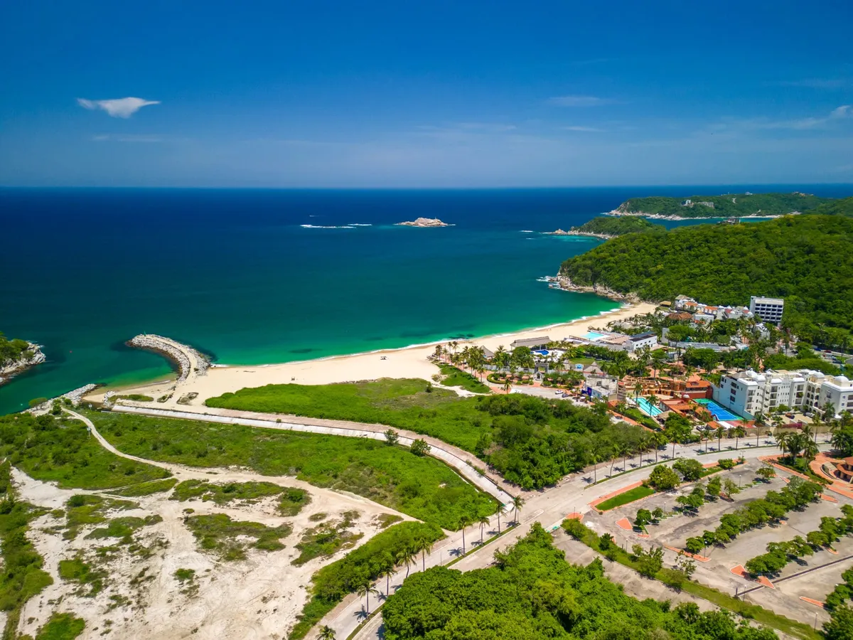 Architectural render at golden hour showcasing sustainable coastal residential development in Huatulco