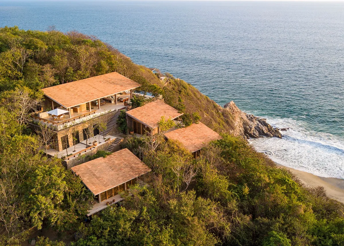 Wide shot of an undeveloped coastal bluff over the Pacific Ocean at golden hour
