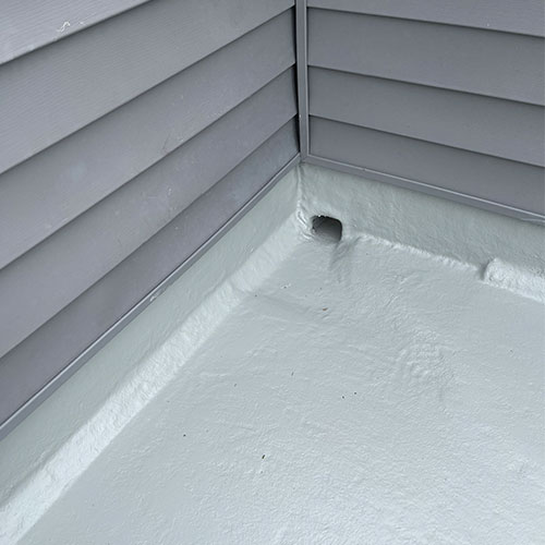 Repaired scupper box and surrounding fiberglass deck area with gray gel coat paint