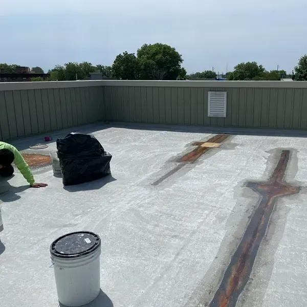 Fiberglass roof repair in Philadelphia, PA, with worker applying sealant and protective coating.