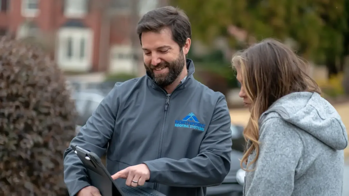 A wooden roof with decorative ornament against blue sky.