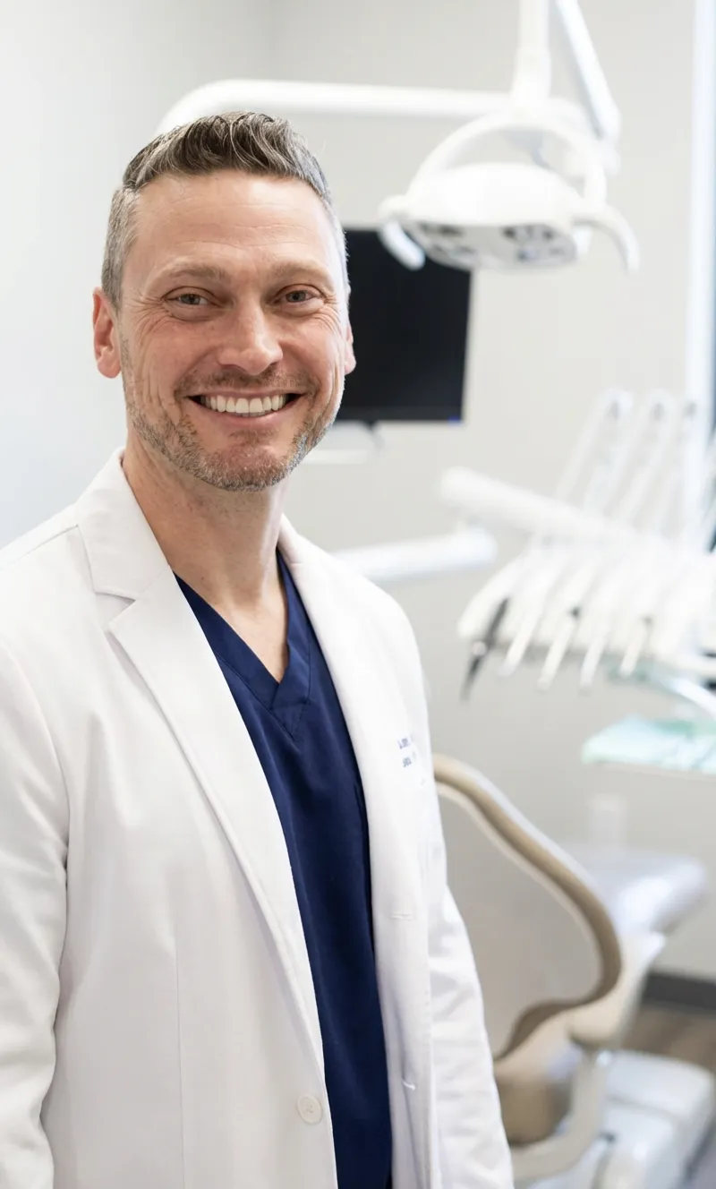 Adult patient holding a ClearCurve aligner case in a modern bright dental clinic.
