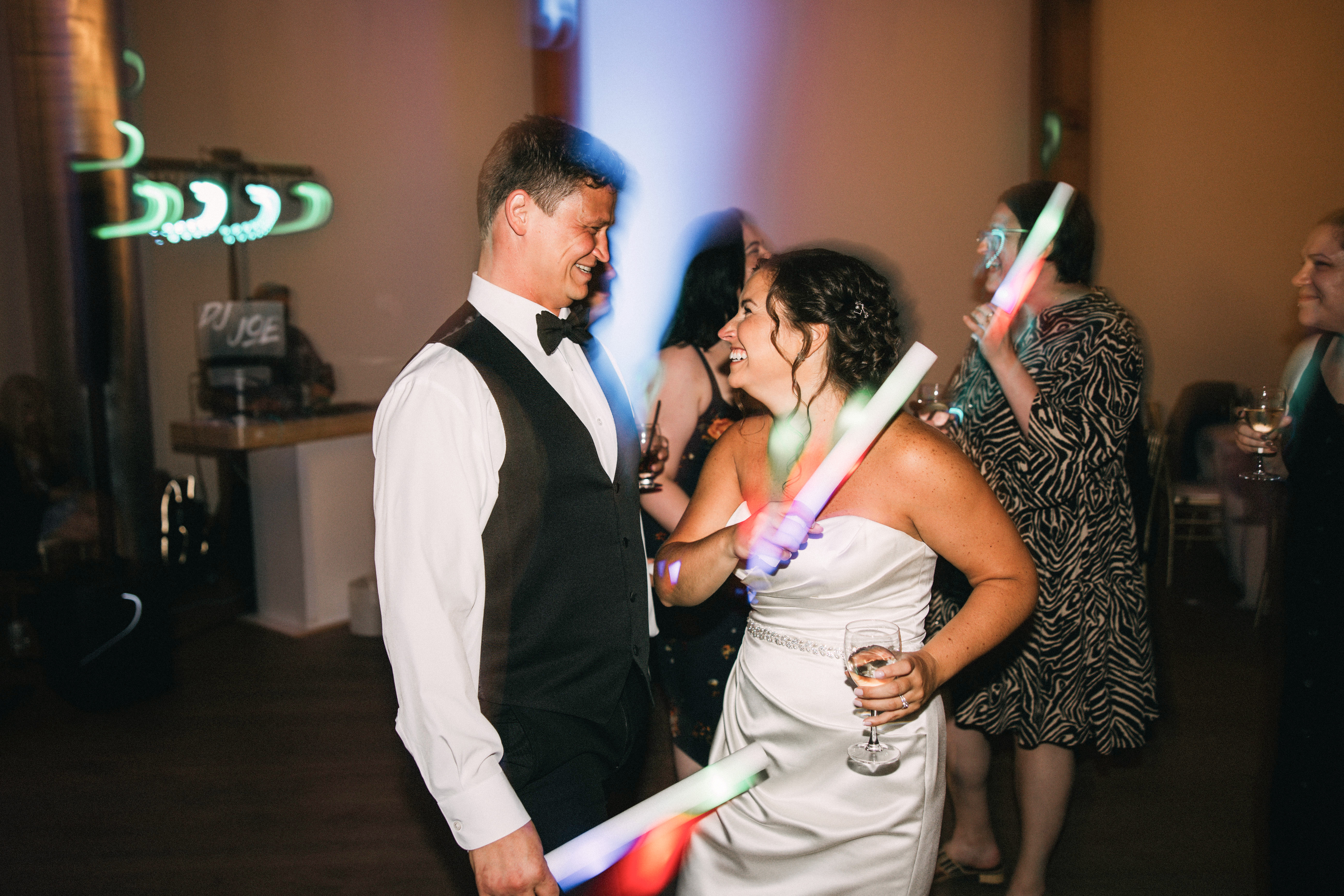 Bride and groom celebrating on a packed dance floor during an energetic wedding reception.