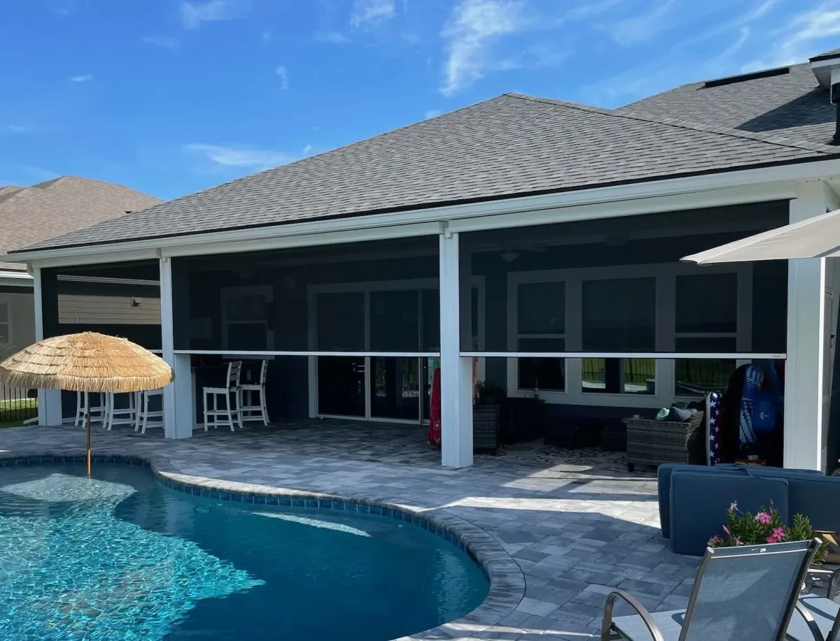 MaxForce retractable hurricane screens enclosing residential pool lanai with outdoor bar area in Florida home