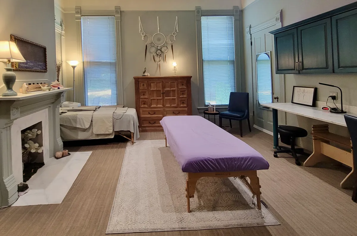 Total Body Being treatment room with bodywork table and fireplace