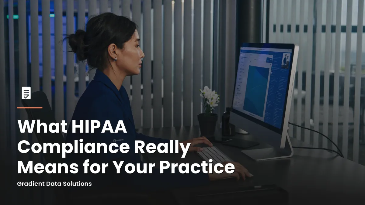Practice administrator at medical office workstation reviewing HIPAA compliance documentation