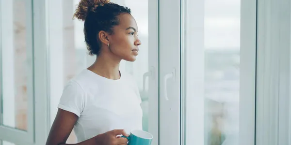 Woman Enjoying Morning Coffee by Window Indoors