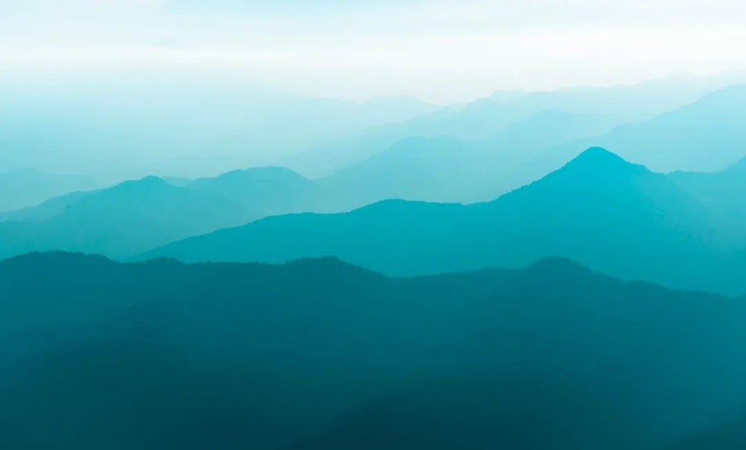 teal coloured misty mountains