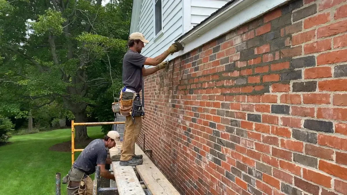 Tuckpointing service in Newburyport MA restoring mortar joints on residential brick wall