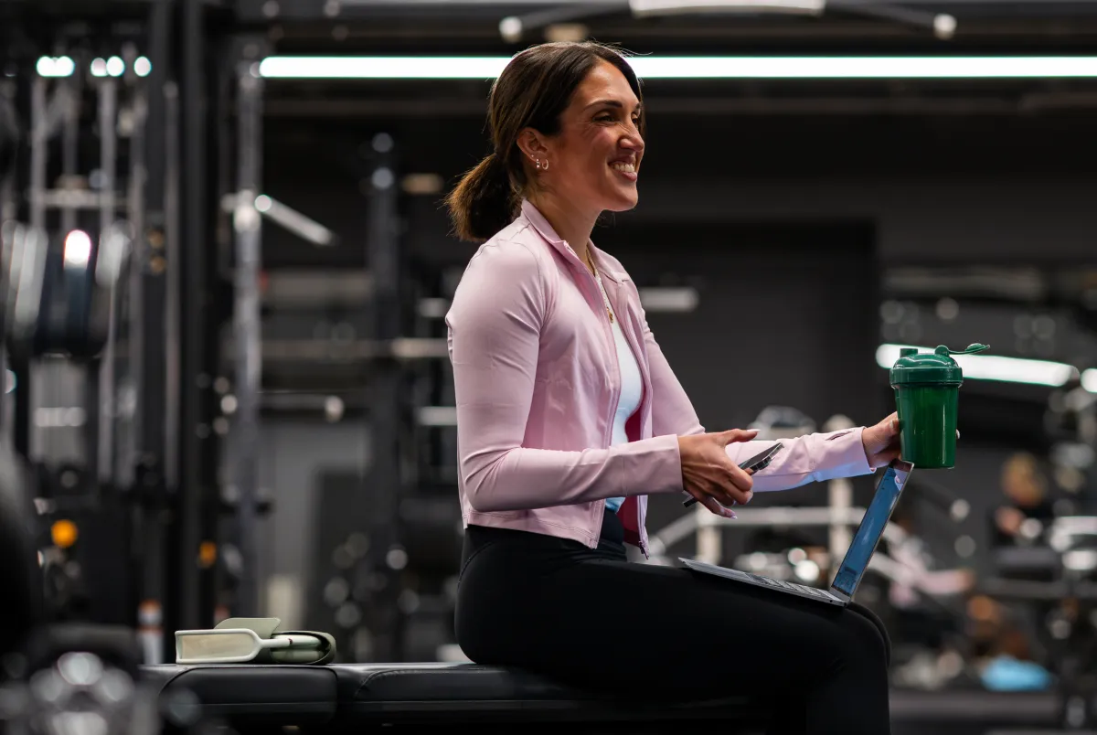 two women in bodysuits leaning against a wall