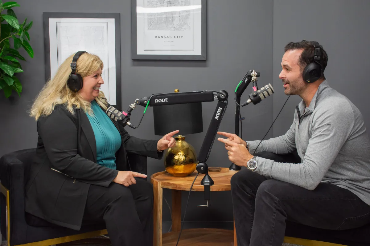 Two mid-level managers practicing a message drill in a bright meeting space after a training; candid action shot.