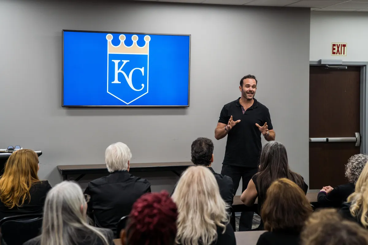 Leadership huddle around a whiteboard reviewing a concise implementation timeline; collaborative discussion.