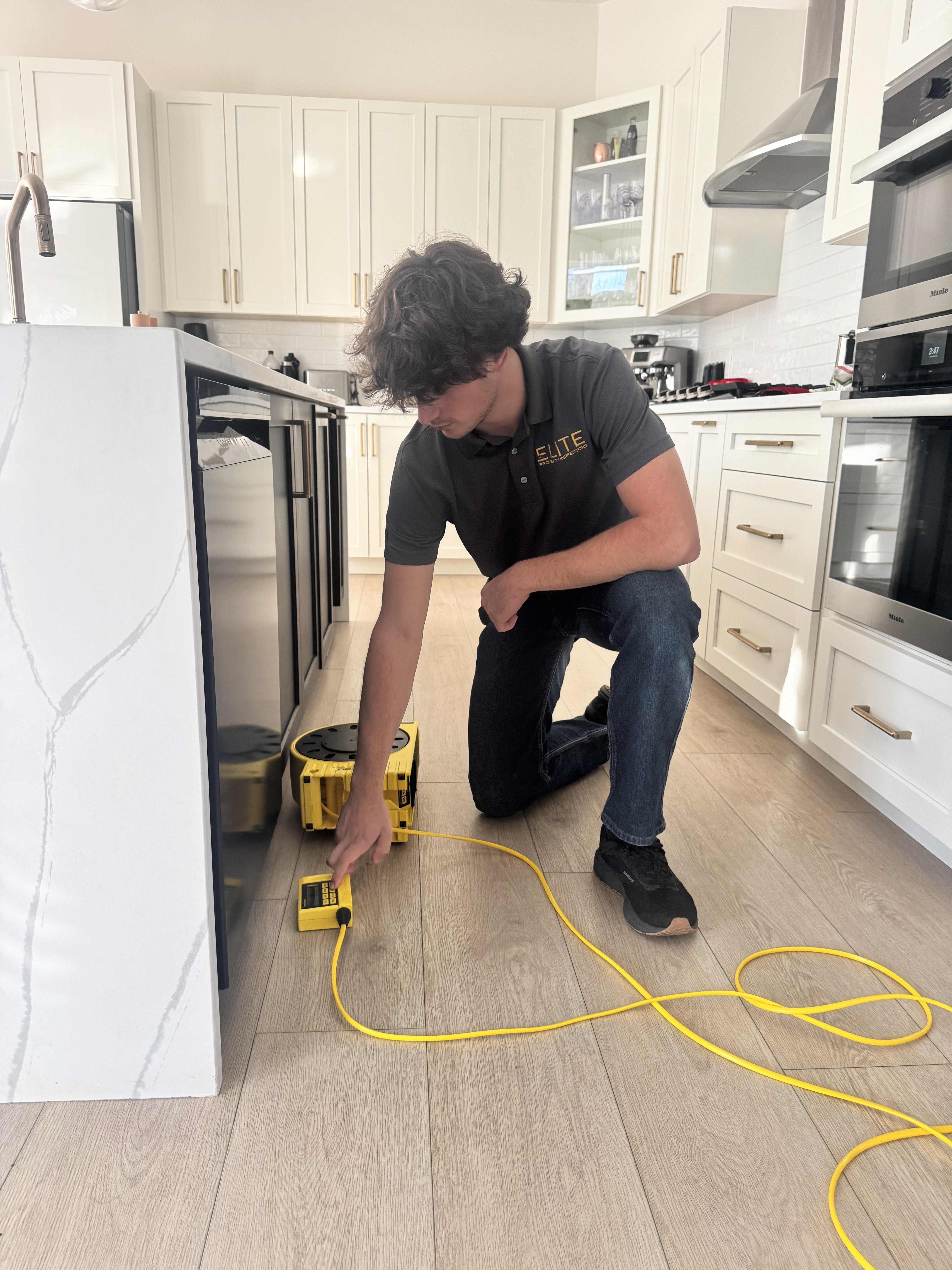 Elite Property Inspectors technician performing home inspection in Panama City, Florida kitchen