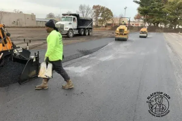 Fresh asphalt driveway being paved during warm weather for optimal pavement maintenance