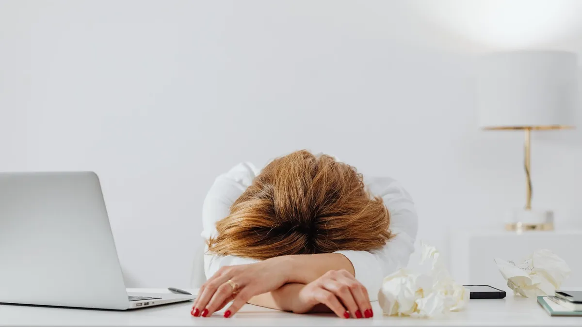Tired woman resting her head on her desk